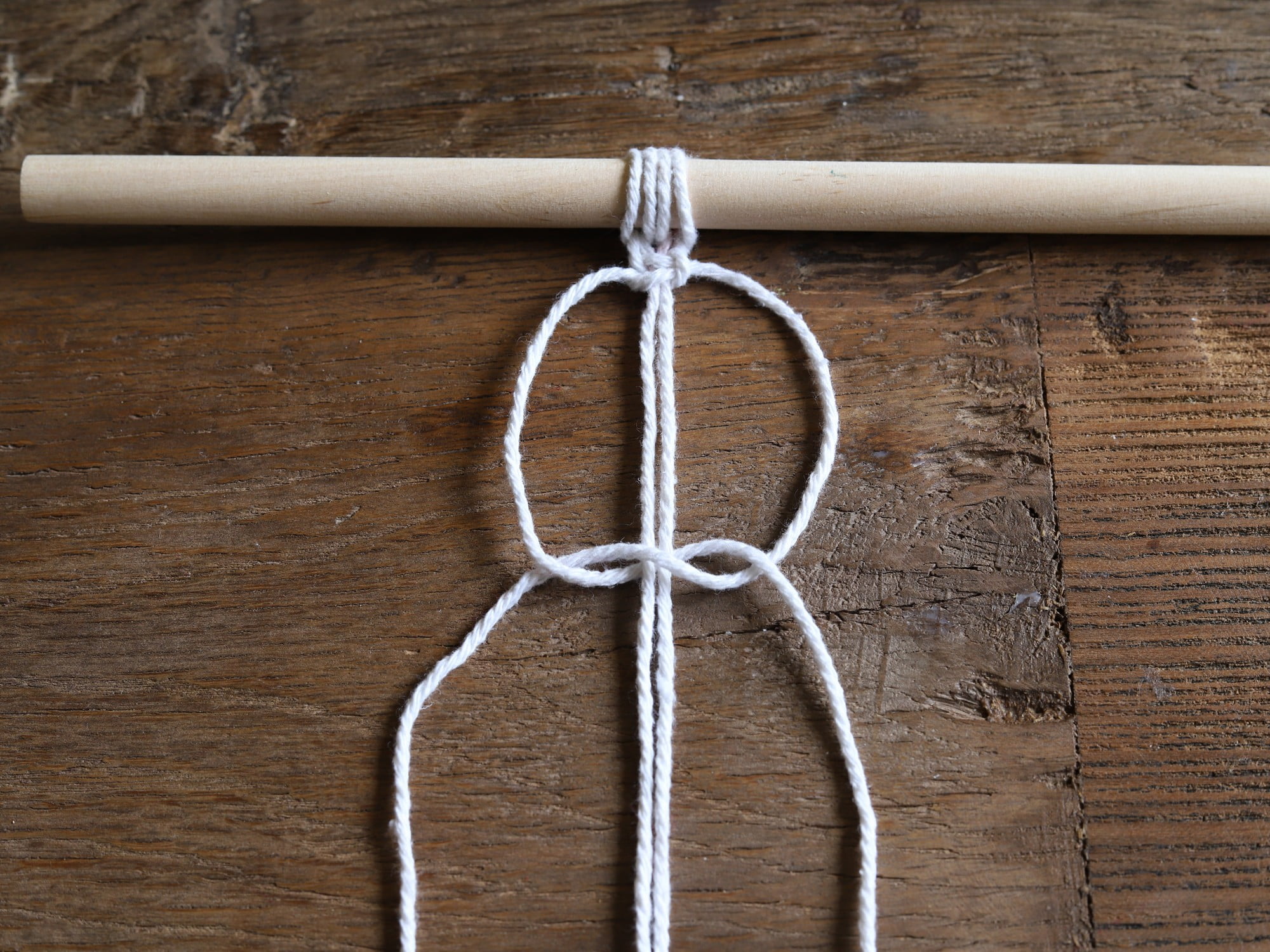 Skrajnie lewy sznurek następnie przełóż pod dwoma środkowymi i wyjmij przez oczko, które powstało przy prawym sznurku.