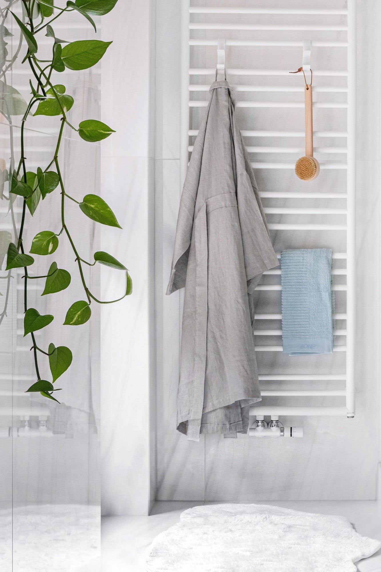 W łazience pojawiają się też naturalne materiały – lniany szlafrok i bambusowa szczotka. 