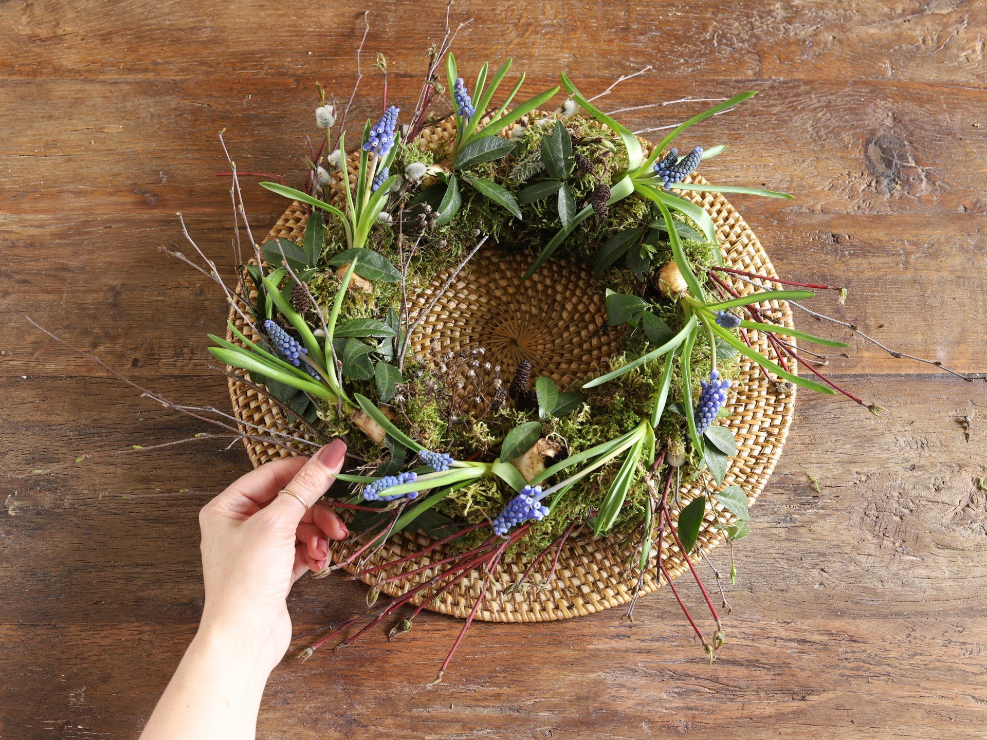 Wiosenny wianek z mchu i kwiatów.